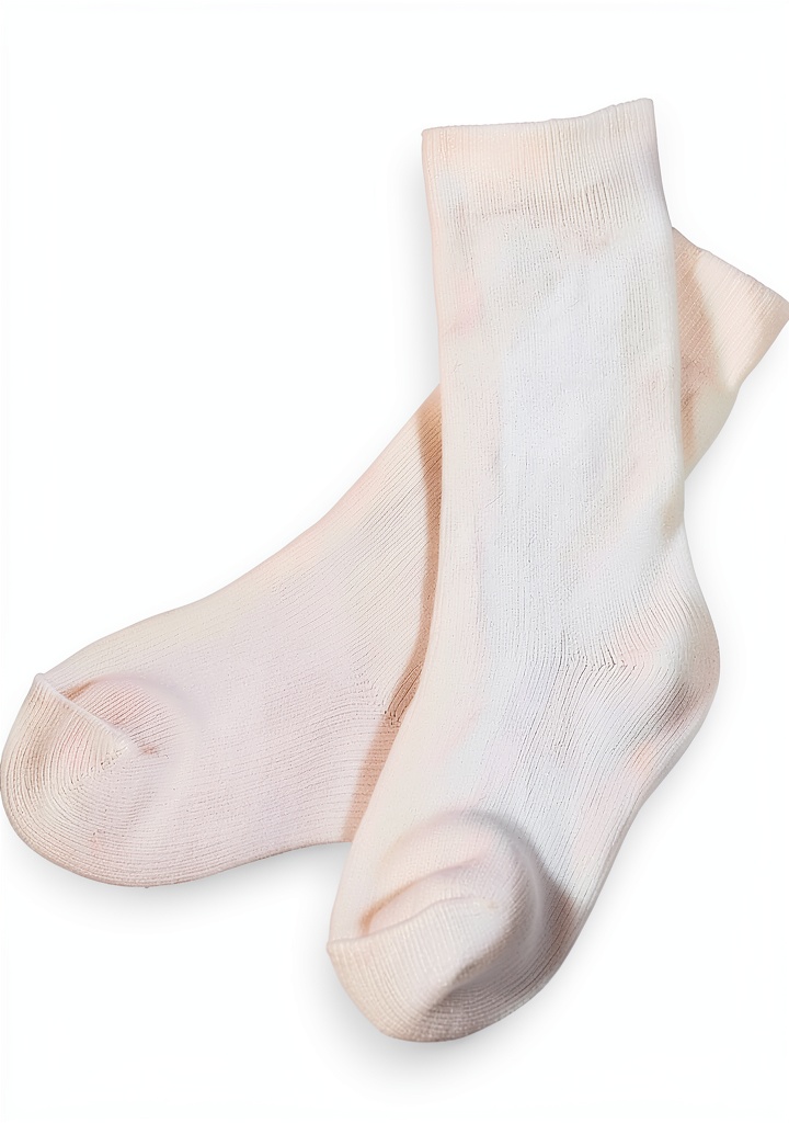 Baby boy wearing white nylon christening socks on a soft blanket